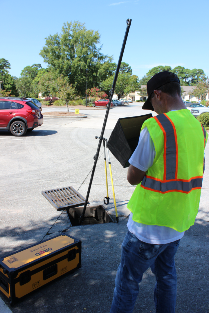 A man in yellow vest holding a laptop.